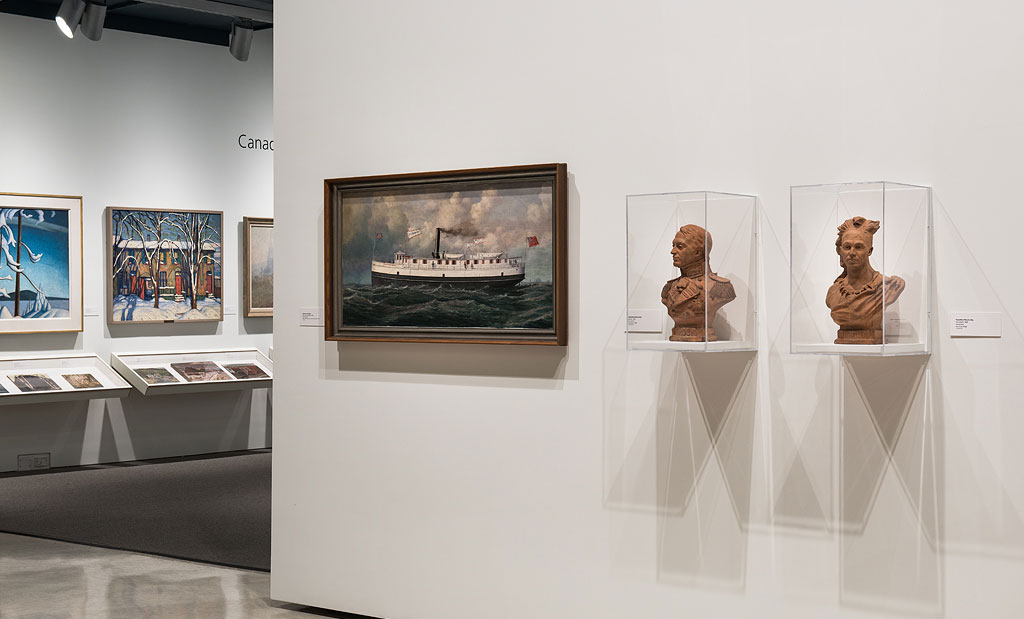 An exhibit in the Art Gallery of Windsor with framed paintings and two bust sculptures